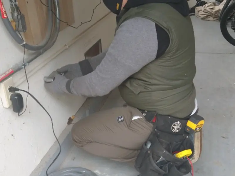 Electrician performing outlet wiring in a Henderson garage
